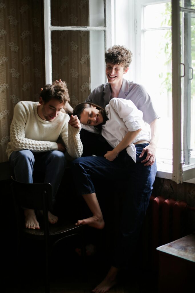 Three friends enjoying a cozy moment by the window, showcasing togetherness.